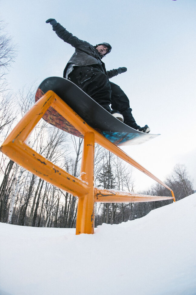 Sean Dillon nosepresses a rail on his snowboard